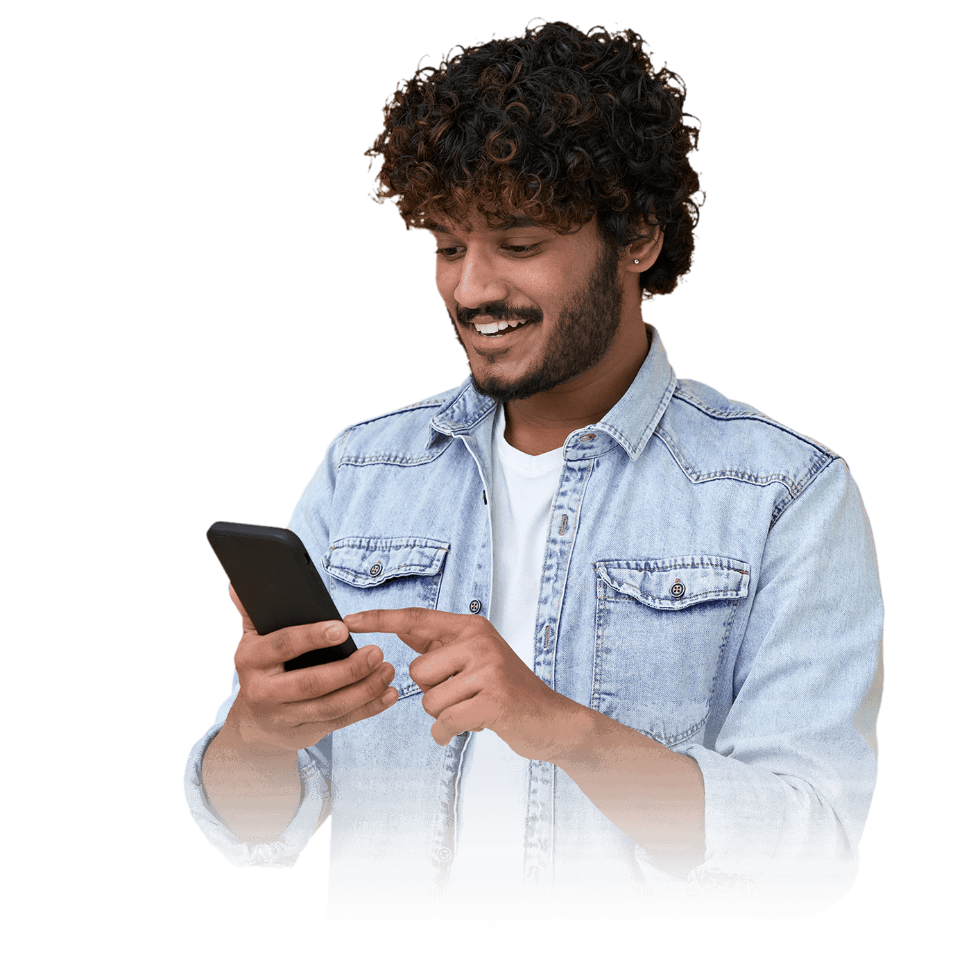 A man in a denim jacket engaging with his mobile phone.