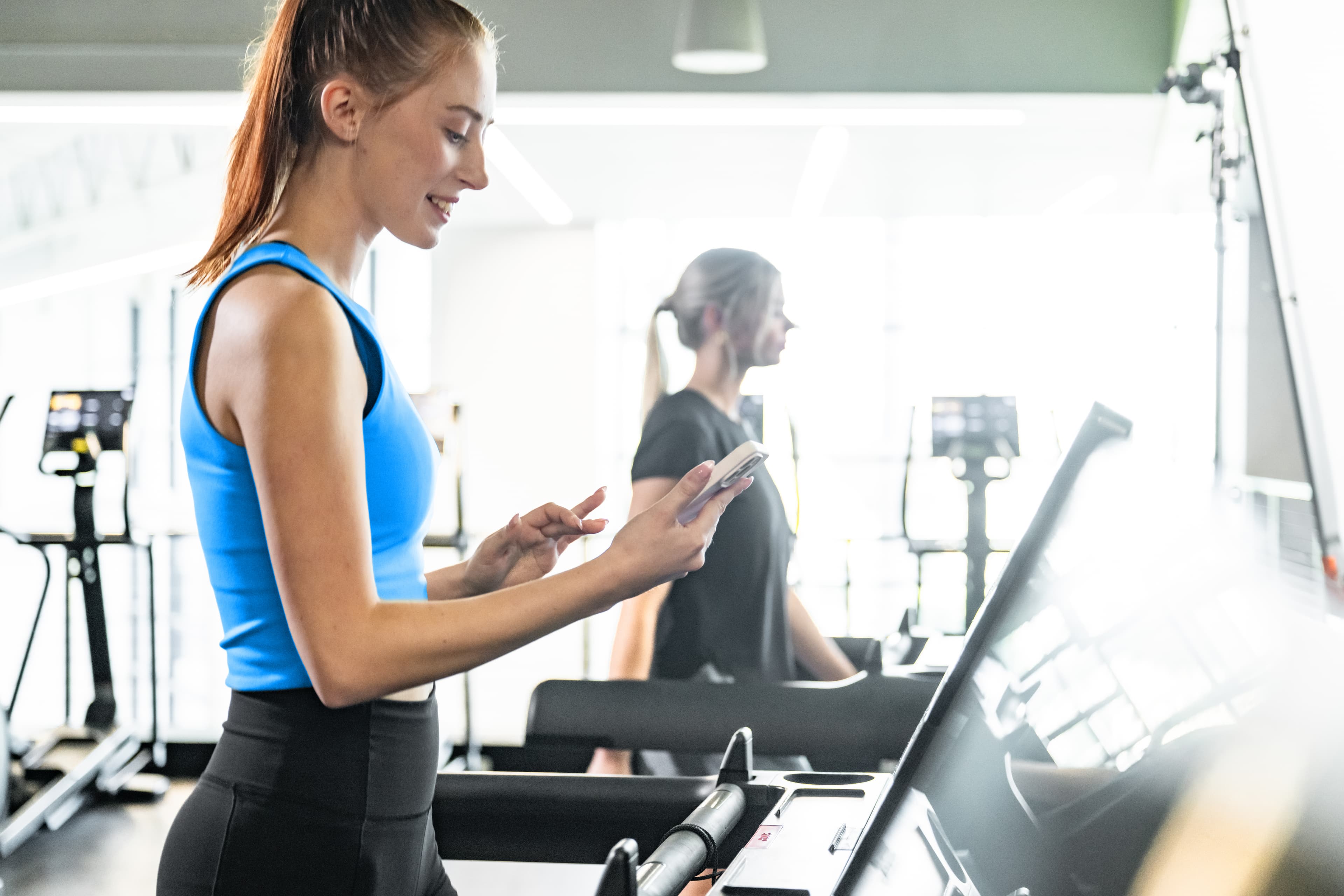 A person using their mobile on the treadmill