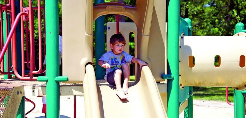 a kid on the slide in the park